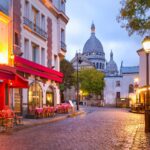 Paris. Montmartre. En gate i kveldsbelysning med Sacre Coeur i bakgrunn. Foto