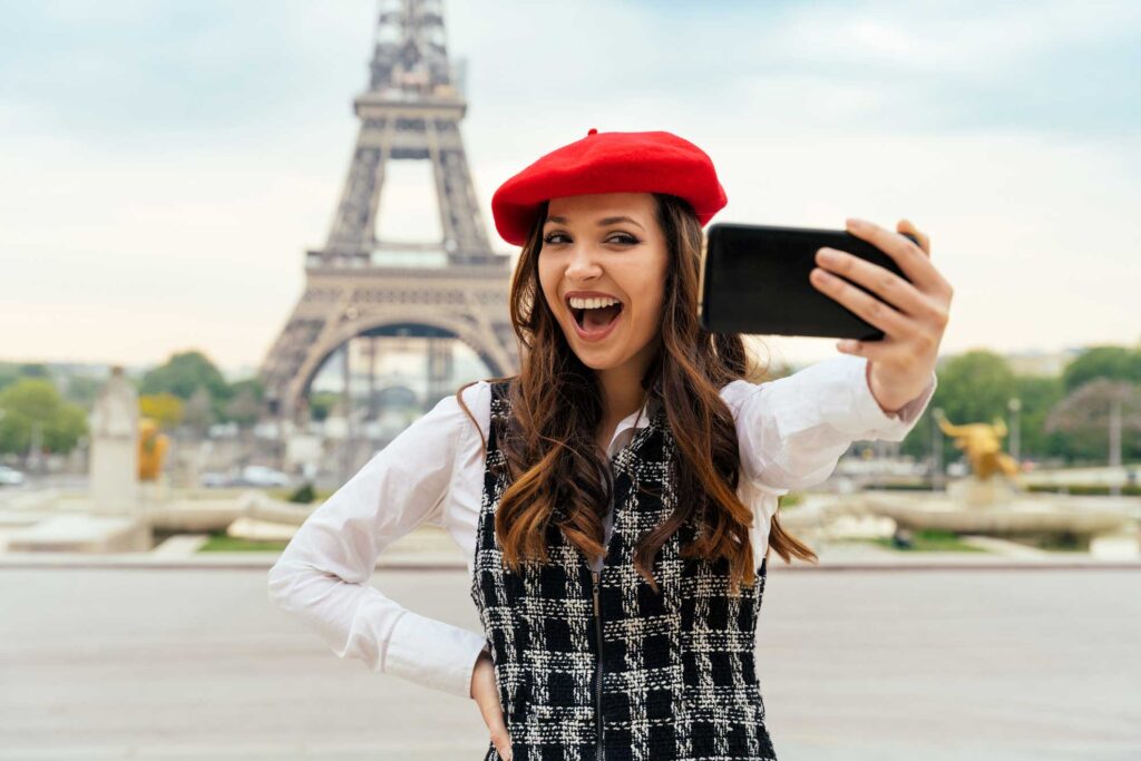 Paris, glad jente tar selfie foran Eiffel-tårnet