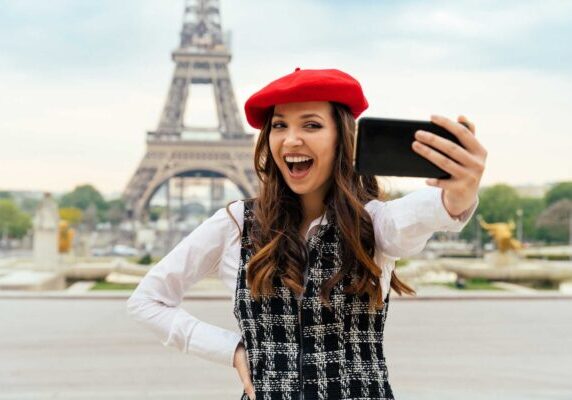 Paris, glad jente tar selfie foran Eiffel-tårnet